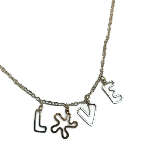 the word LOVE spelled out with delicate handmade letters with a flower for the "0" on dainty silver chain
