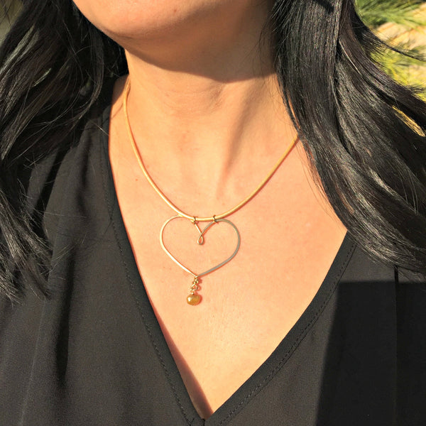 gold heart necklace on gold leather on pretty model
