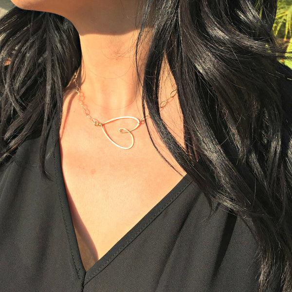 silver & gold sideways heart necklace on pretty model